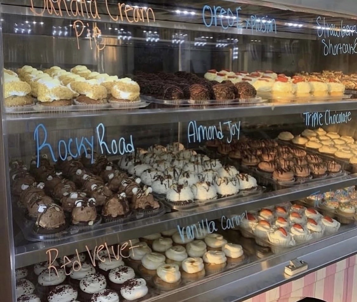 Cupcakes displayed neatly in a bakery case